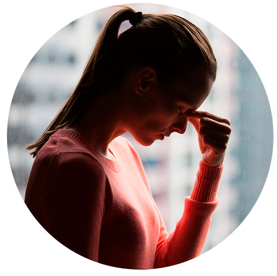 Mujer se muestra preocupada, con la cabeza baja, su mano toca su frente