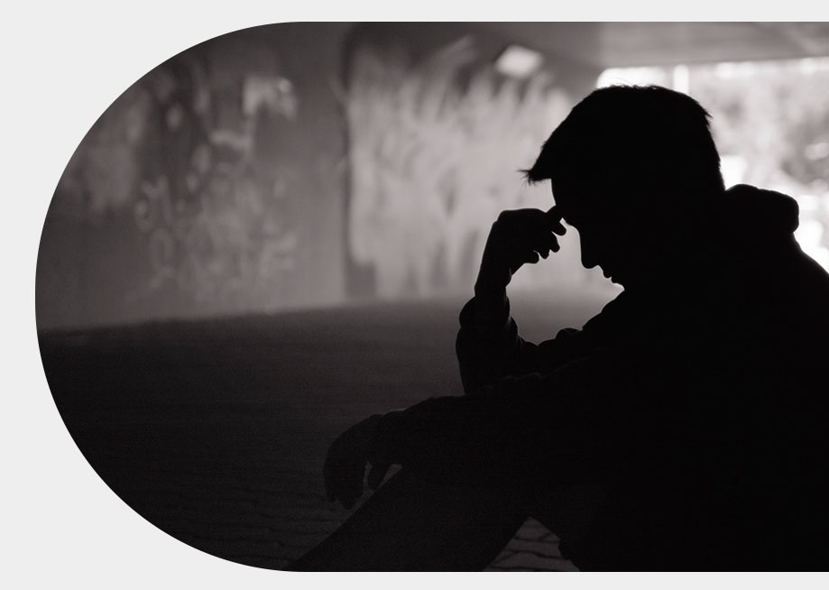 Joven agachado, se muestra cabizbajo, se muestra afligido