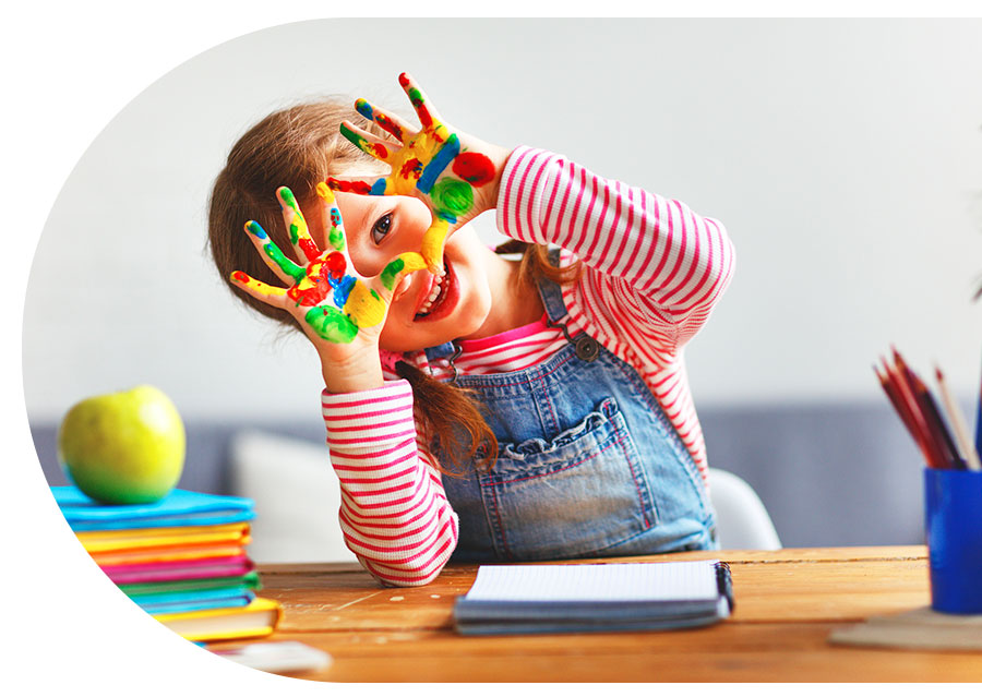 Una niña muestran sus manos pintadas de diferentes colores 
